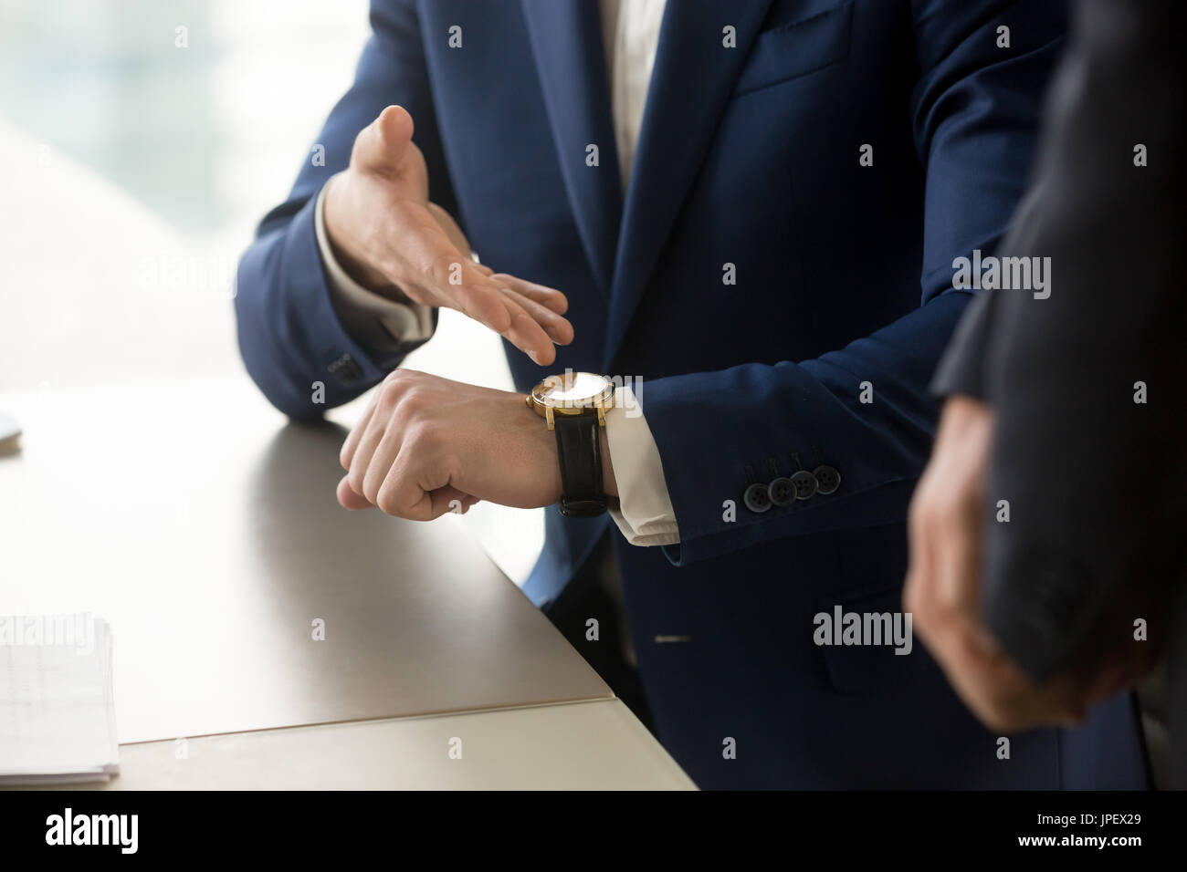 Imprenditore puntando sull'orologio da polso, puntualità, la gestione del tempo Foto Stock