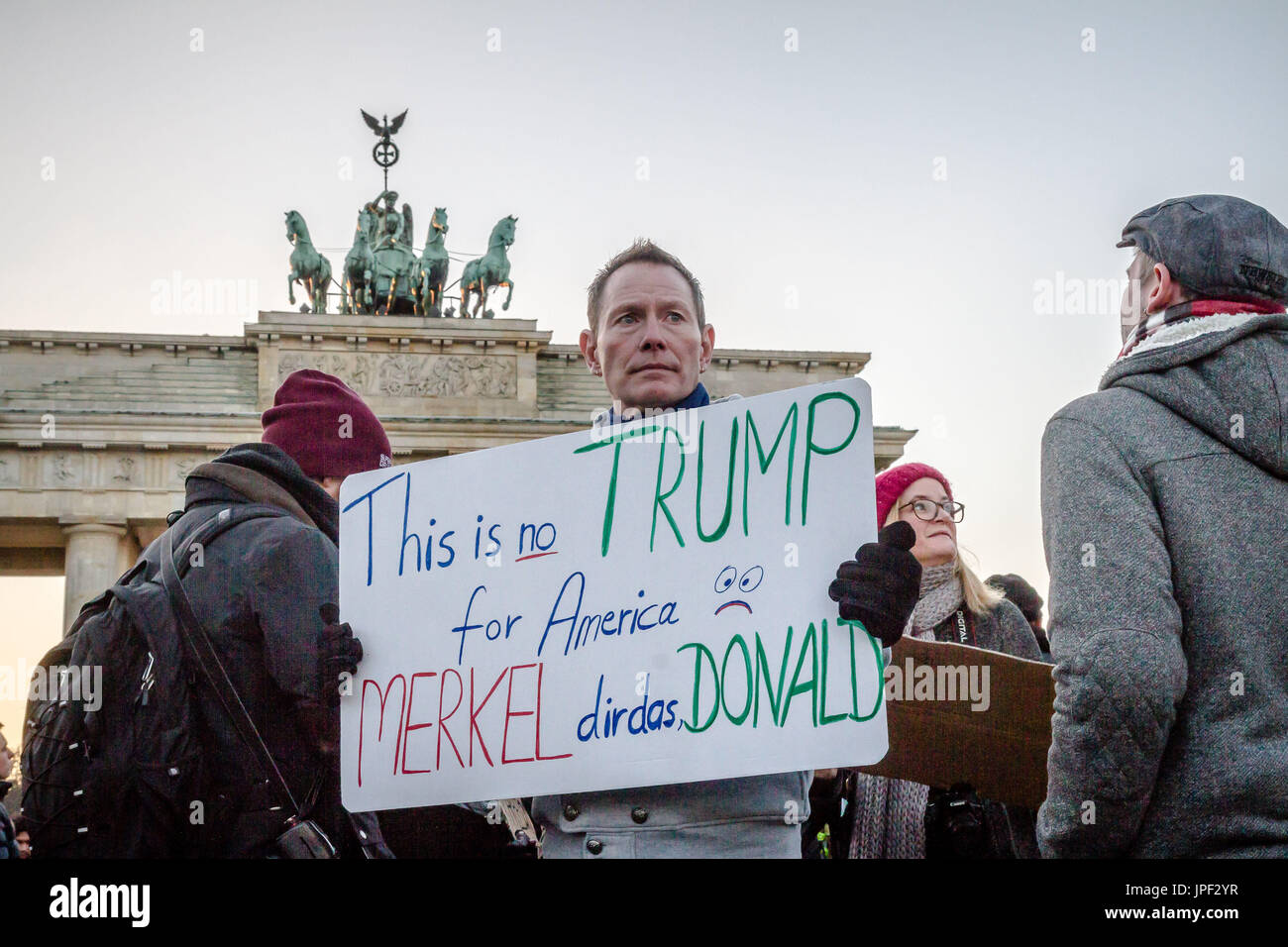 Un uomo è in possesso di un anti-Trump cartellone di fronte alla Porta di Brandeburgo a Berlino per protestare contro le elezioni di Donald Trump al presidente. Foto Stock