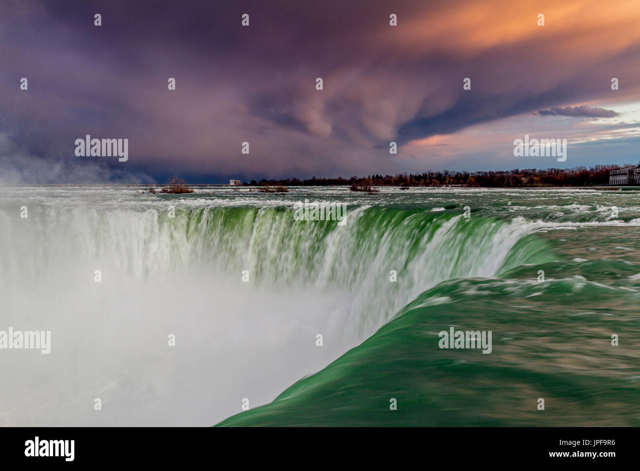 Le fragorose cortina d'acqua si riversano sulle cascate Horseshoe delle Cascate del Niagara, Ontario, Canada, mentre in lontananza si accumula un cielo minaccioso Foto Stock