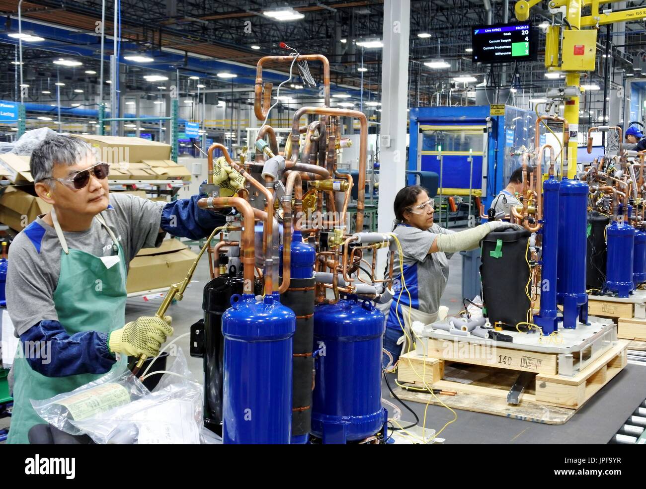 I dipendenti della Daikin Industries Ltd lavorano nella linea di produzione  di unità di condizionamento dell'aria interna presso lo stabilimento di  Kusatsu nella prefettura di Shiga, Giappone occidentale, il 20 marzo 2015.