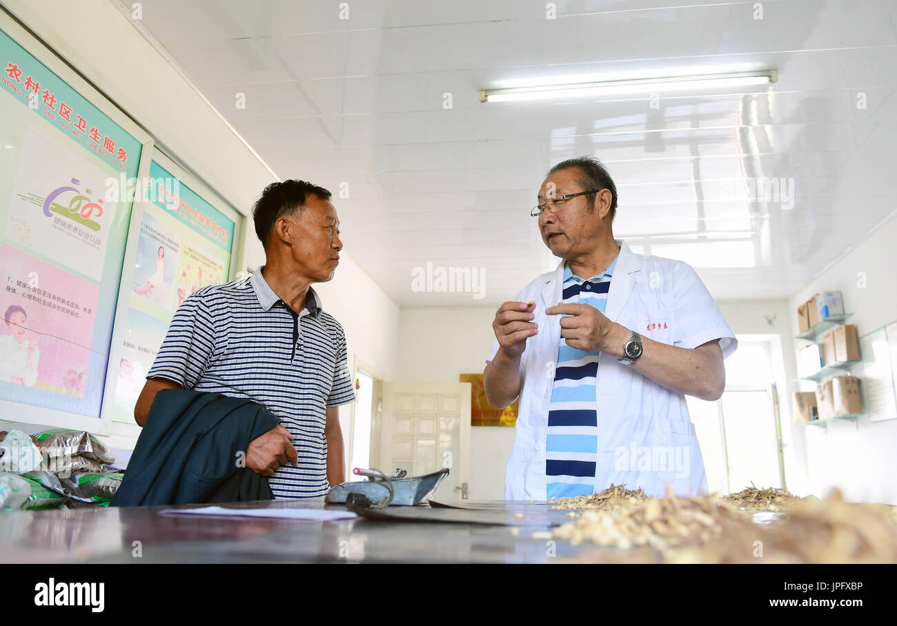 (170802) -- JILIN, 2 agosto 2017 (Xinhua) -- Yue Ruhua (destra) fornisce consulenza medica di un paziente presso Dakouqin villaggio di Houtuanshan città nella città di Jilin, a nord-est della Cina di provincia di Jilin, 31 luglio 2017. 64-anno-vecchio Yue Ruhua è stato un medico rurale per 37 anni. Diverso da medici in area urbana e rurale i medici devono rendere casa chiamate frequentemente. Secondo Yue Ruhua la moglie di Jing Yuhong, cadde sulla strada robusto e siamo stati alzati fino a tardi per il soccorso di pazienti innumerevoli volte. In 2013, Yue Ruhua è stato diagnosticato con infarto miocardico acuto e inviati alla unità di cure intensive. Gli abitanti di un villaggio sollevata più di 20 Foto Stock