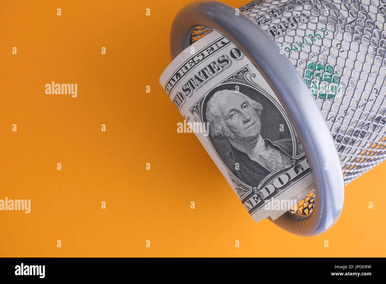 Le fatture del dollaro in un cestino su sfondo giallo. Close up. Foto Stock