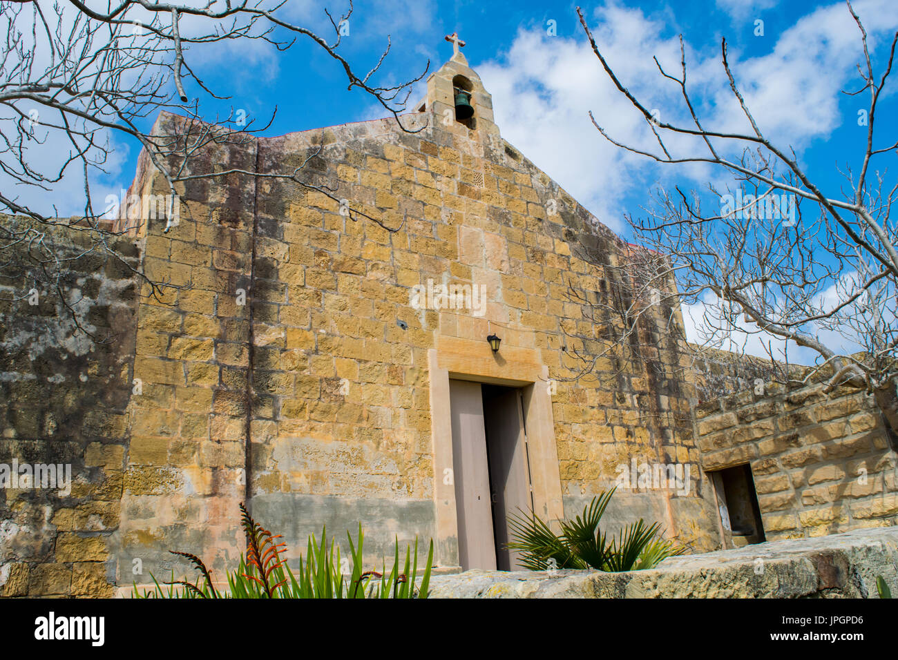 Saint George's cappella, una cappella medievale in buone condizioni e oggi utilizzato, a Birzebugga su un nuvoloso ma bella giornata invernale, porta leggermente socchiusa, Malta Foto Stock