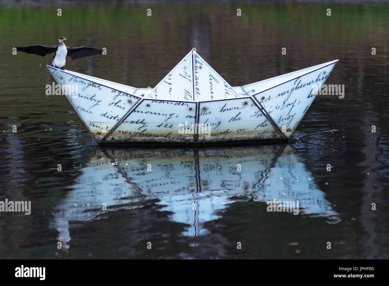 Cormorano sulla barca di carta di scultura del River Torrens, Adelaide, Australia del Sud. Foto Stock