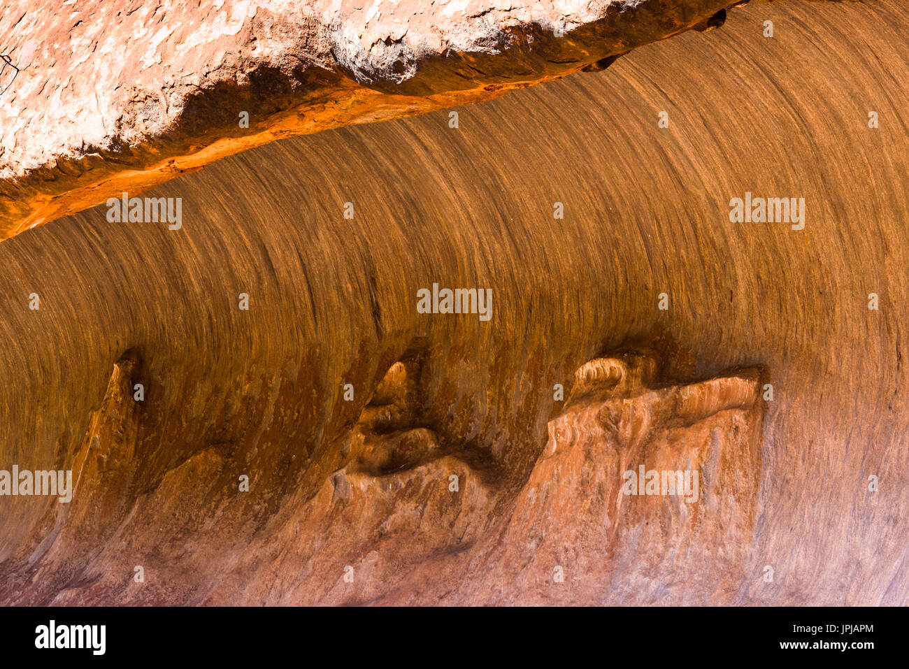 Grotta di wave rock formazione a Uluru aka Ayers rock, Territorio del Nord, l'Australia. Foto Stock
