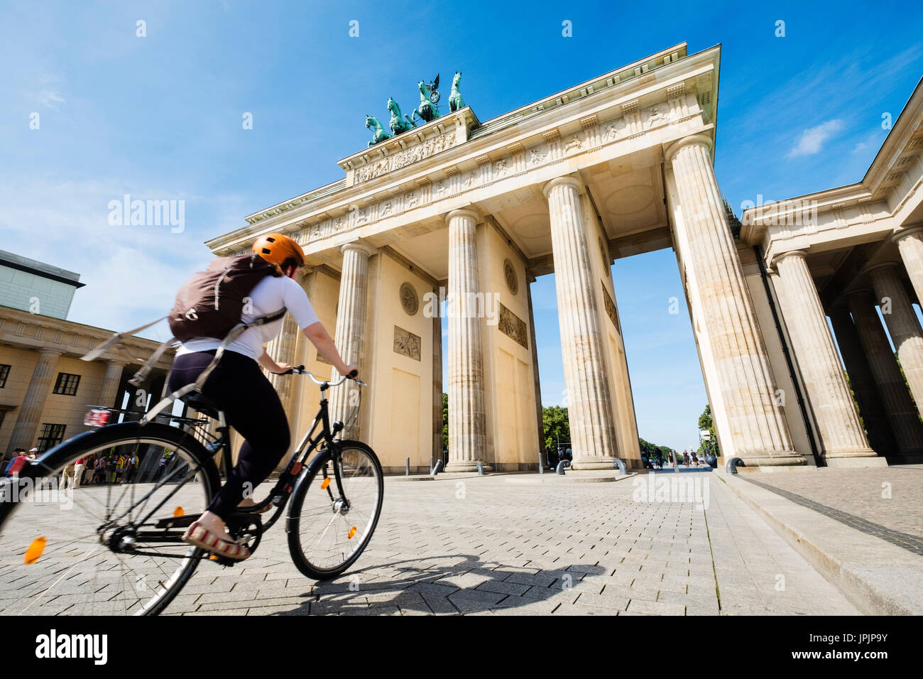 Ciclista in sella passato Porta di Brandeburgo nel quartiere Mitte di Berlino Germania Foto Stock