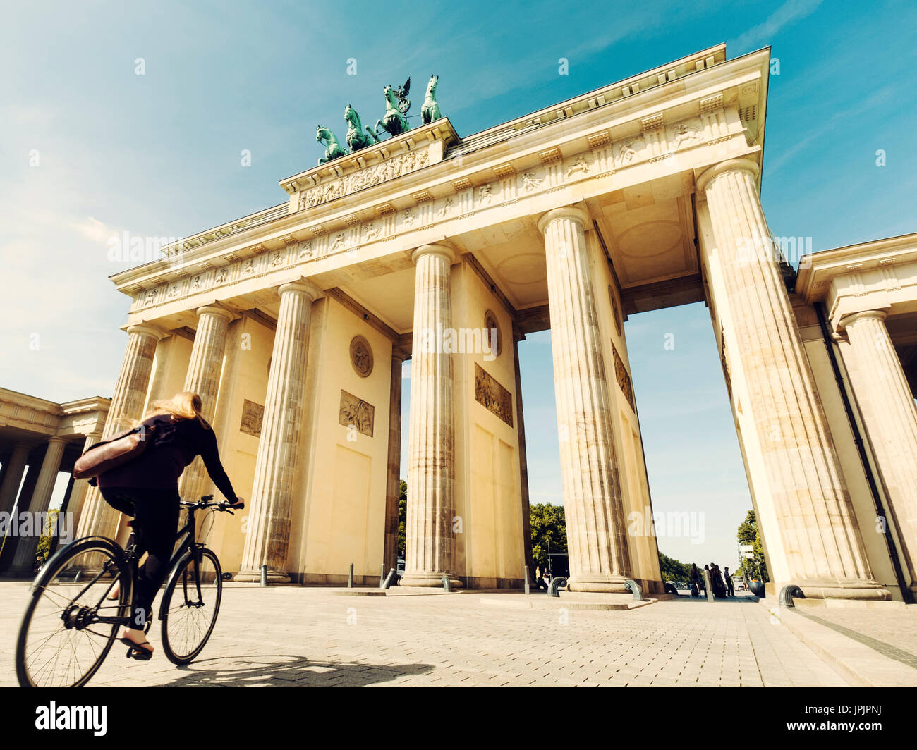 Ciclista in sella passato Porta di Brandeburgo nel quartiere Mitte di Berlino Germania Foto Stock