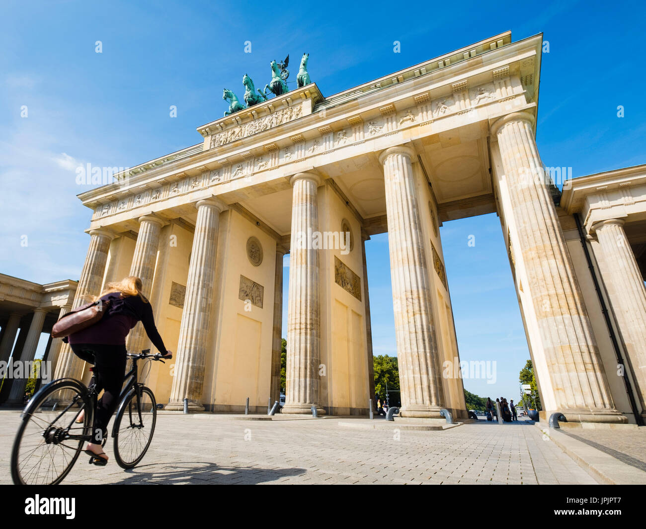 Ciclista in sella passato Porta di Brandeburgo nel quartiere Mitte di Berlino Germania Foto Stock