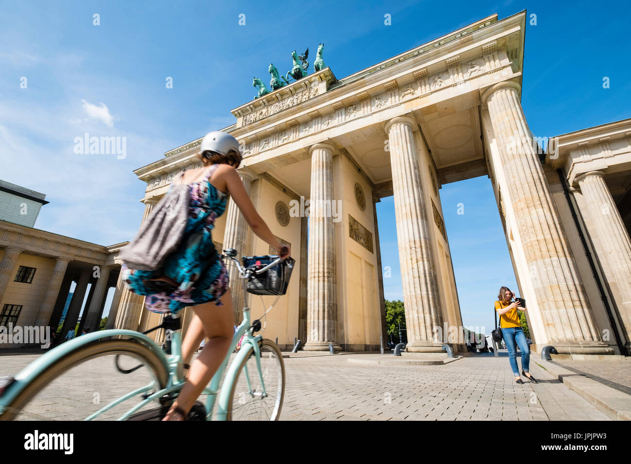 Ciclista in sella passato Porta di Brandeburgo nel quartiere Mitte di Berlino Germania Foto Stock
