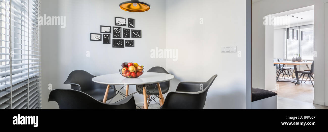 Casa bianca di interno con lampada, moderno tavolo rotondo e sedie nere, panorama Foto Stock