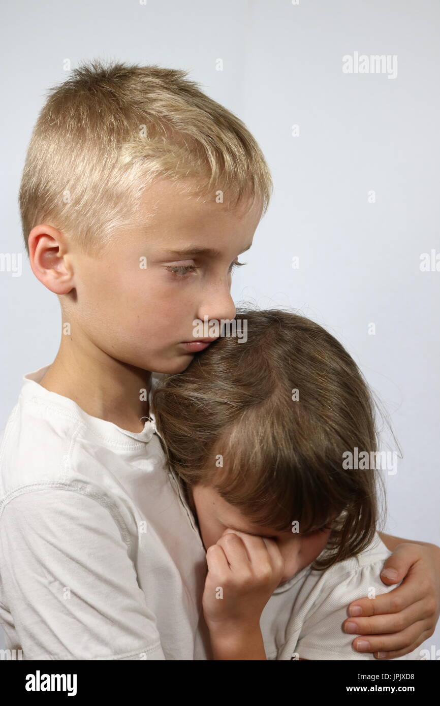 Ritratto di piccola sorella che grida nel fratello di braccia Foto Stock