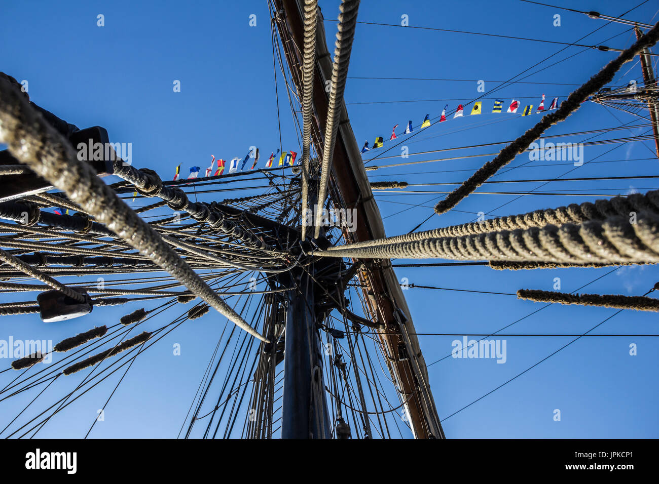 Parte nautico di una barca o un grande vecchio veliero con cordicelle, rigging, vela, piloni, nodi, segnale bandiere blu cielo Foto Stock