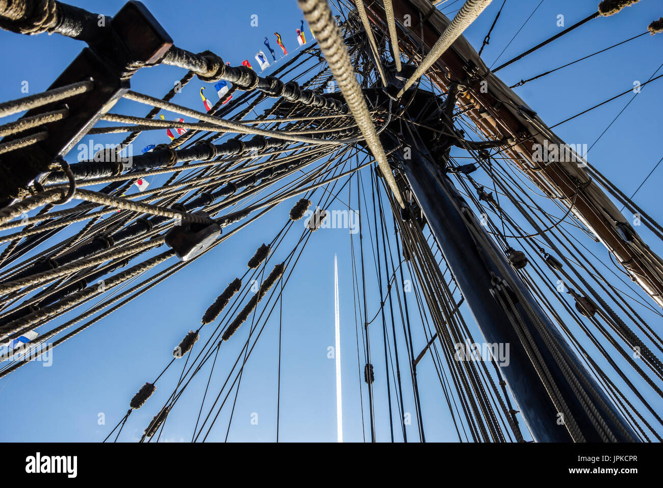 Parte nautico di una barca o un grande vecchio veliero con cordicelle, rigging, vela, piloni, nodi, segnale bandiere blu cielo Foto Stock