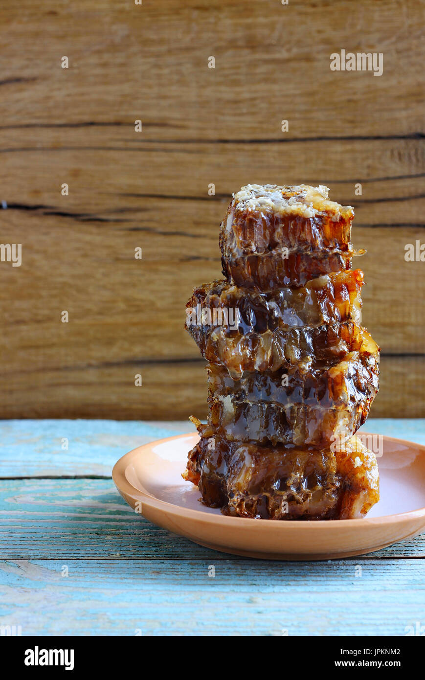 Il miele nel pettine sul tavolo di legno tonificante Foto Stock