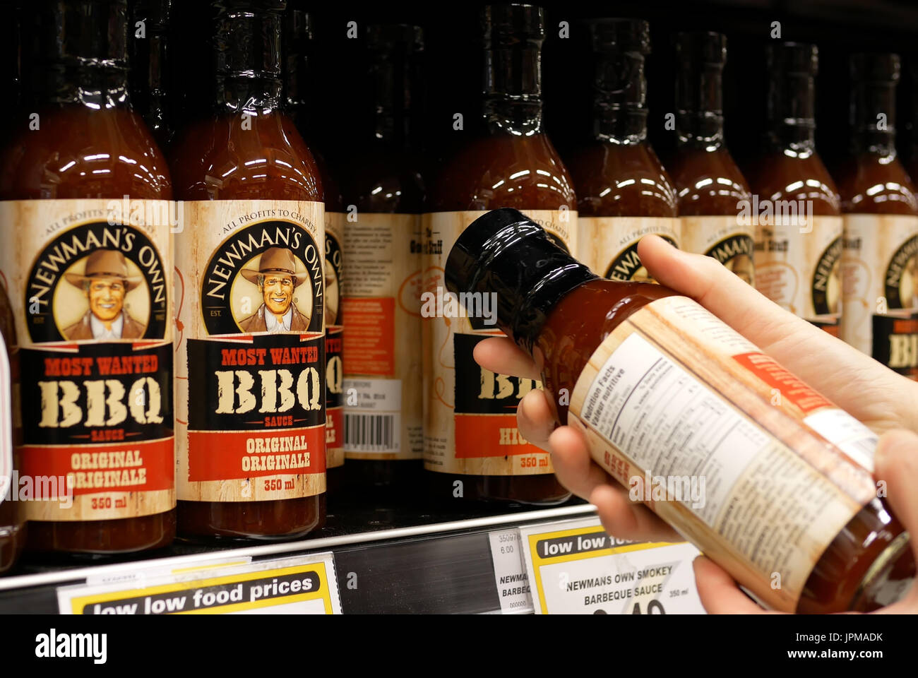 New Westminster, BC, Canada - 15 Aprile 2017 : Donna controllo Newmans bbq sauce ingredienti all'interno di comprare alimenti bassa store Foto Stock