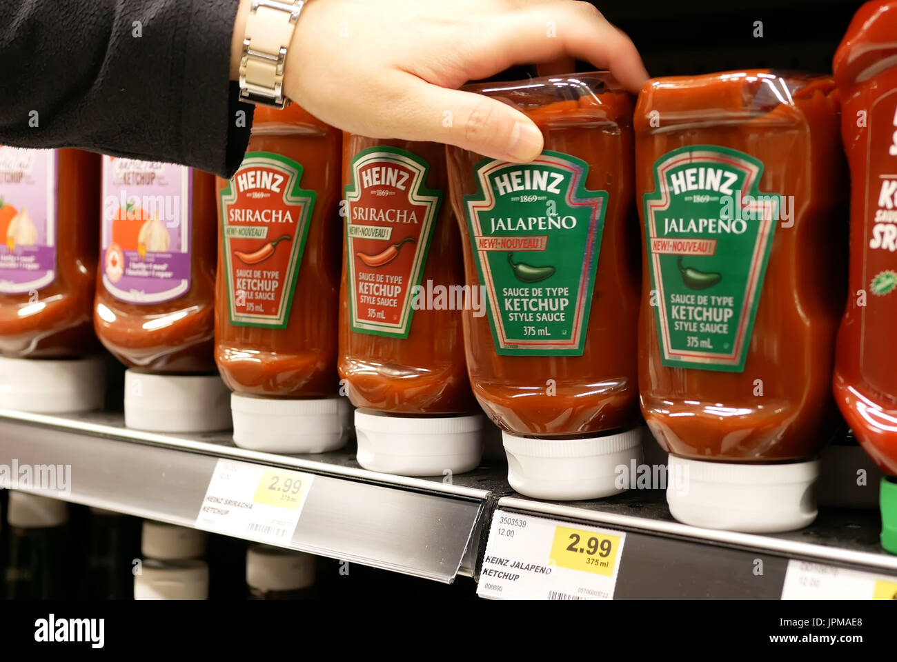 New Westminster, BC, Canada - 15 Aprile 2017 : Donna acquisto jalapeno Heinz ketchup all'interno di comprare alimenti bassa store Foto Stock