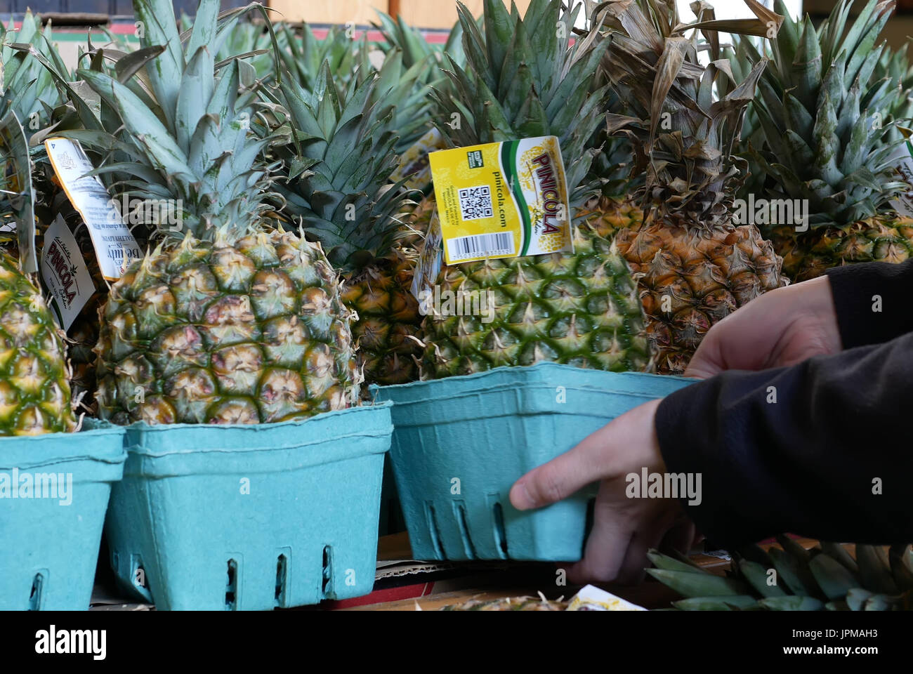 Persone selezionando ananas all'interno del supermercato reparto di produzione Foto Stock