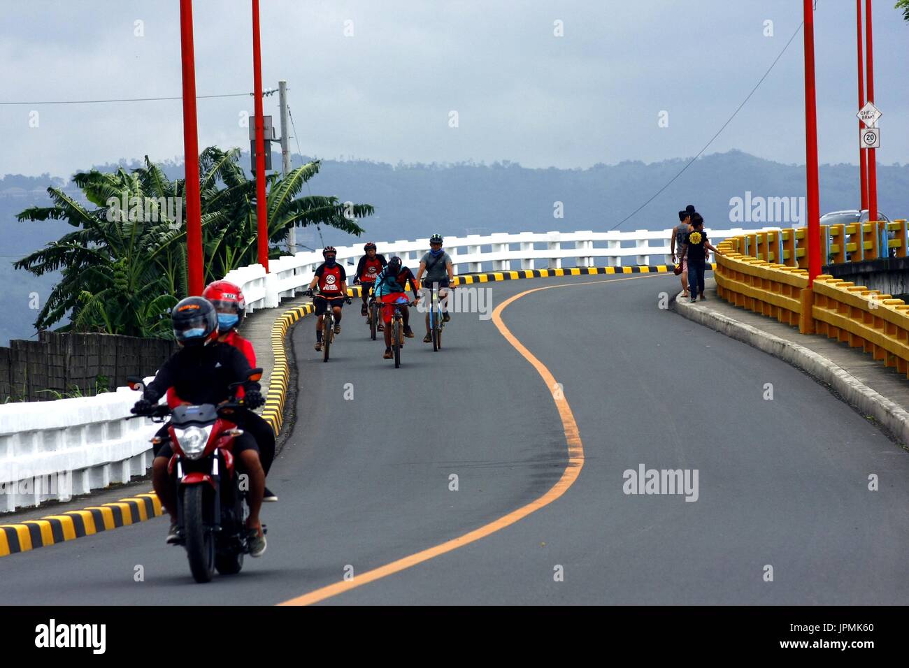 MARIKINA City, Filippine - 30 luglio 2017: i ciclisti e i motociclisti attraversano il ponte Tumana in Marikina City. Foto Stock