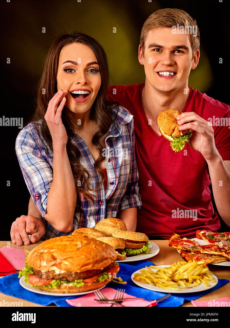 Paio di mangiare fast food. L uomo e la donna a mangiare hamburger. Foto Stock