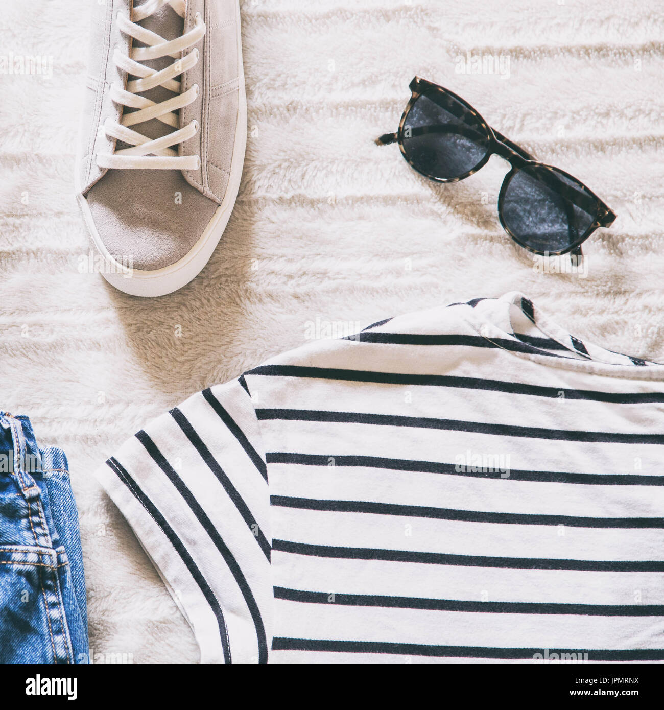 Appartamento donne laiche moda. trendy hipster vestiti e accessori top view. outfit collage con jeans rigato, t-shirt, plimsolls grigio e occhiali da sole. Foto Stock