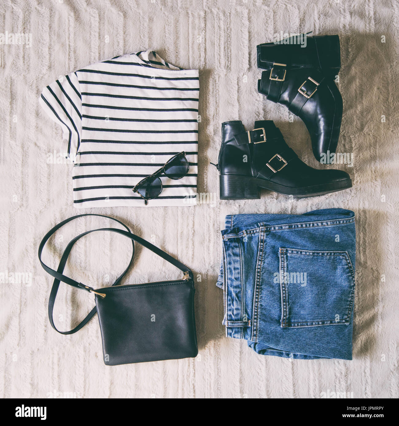 Molla di perfetta vestito. laici piatta di un trendy moda outfit, occhiali  da sole, dei jeans e maglietta a strisce, nera Stivaletti e una piccola ed  elegante borsa nera Foto stock -