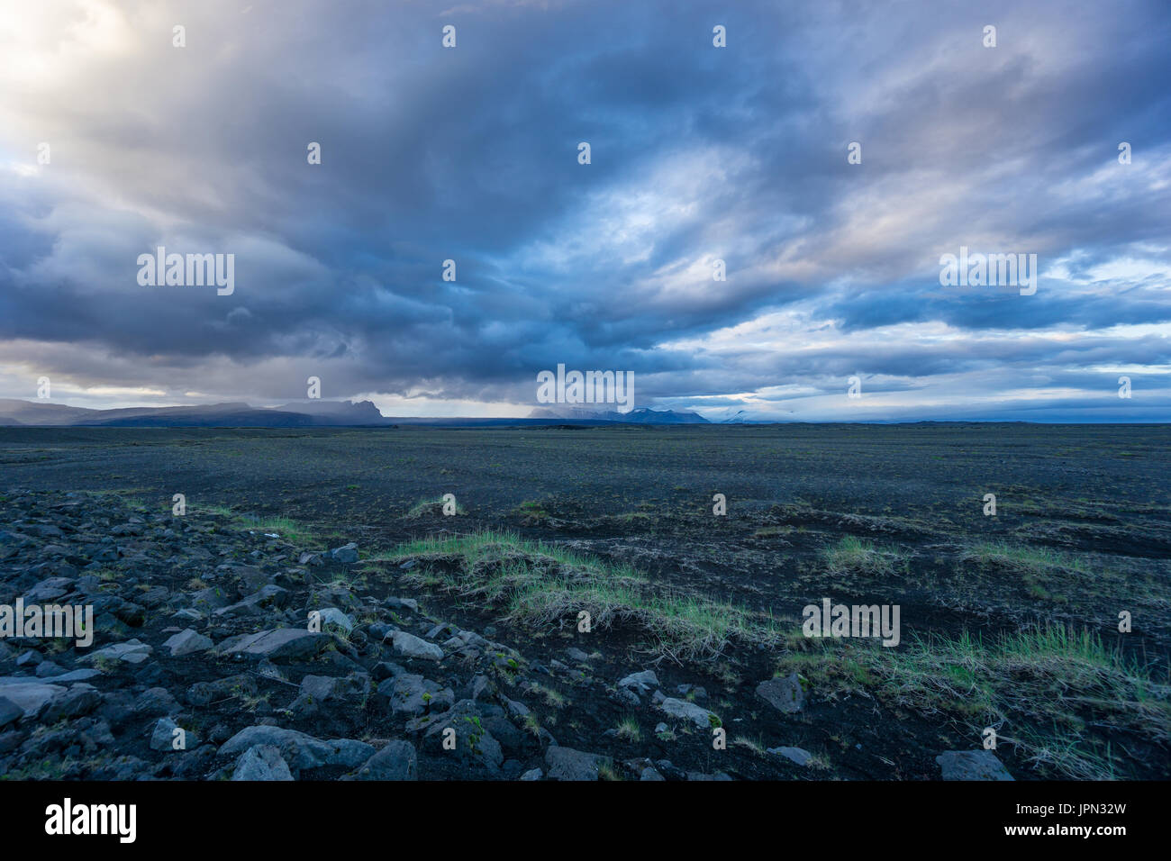 Islanda - Masterizzazione di cielo sopra il nero di infiniti campi di lava e paesaggio di montagna Foto Stock