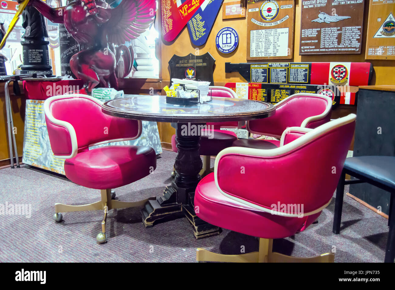 Un militare cafe con tre rosso e bianco pelle sedie girevoli. Foto Stock