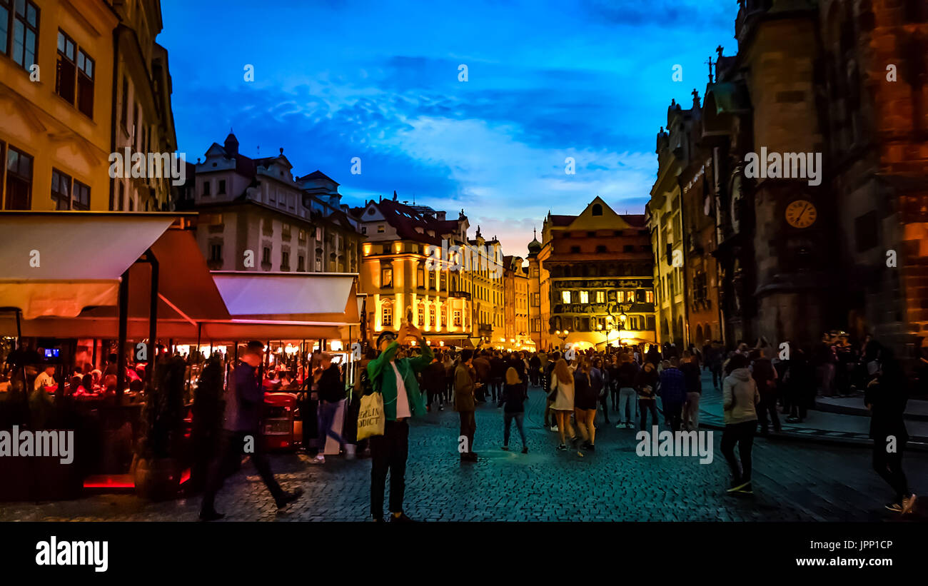 Una colorata notte fuori in città Vecchia Praga vicino all'orologio astronomico con i turisti locali, caffetterie e colorata illuminazione Foto Stock