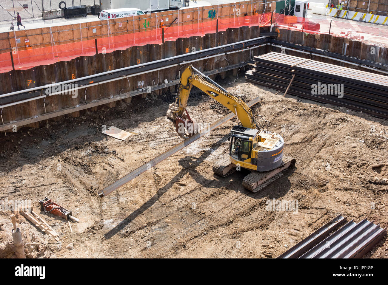 Un cingolato escavatore benna usata come una pinza rotante mover con tracce continue e gru di sollevamento su un sito in costruzione nella città di New York Foto Stock