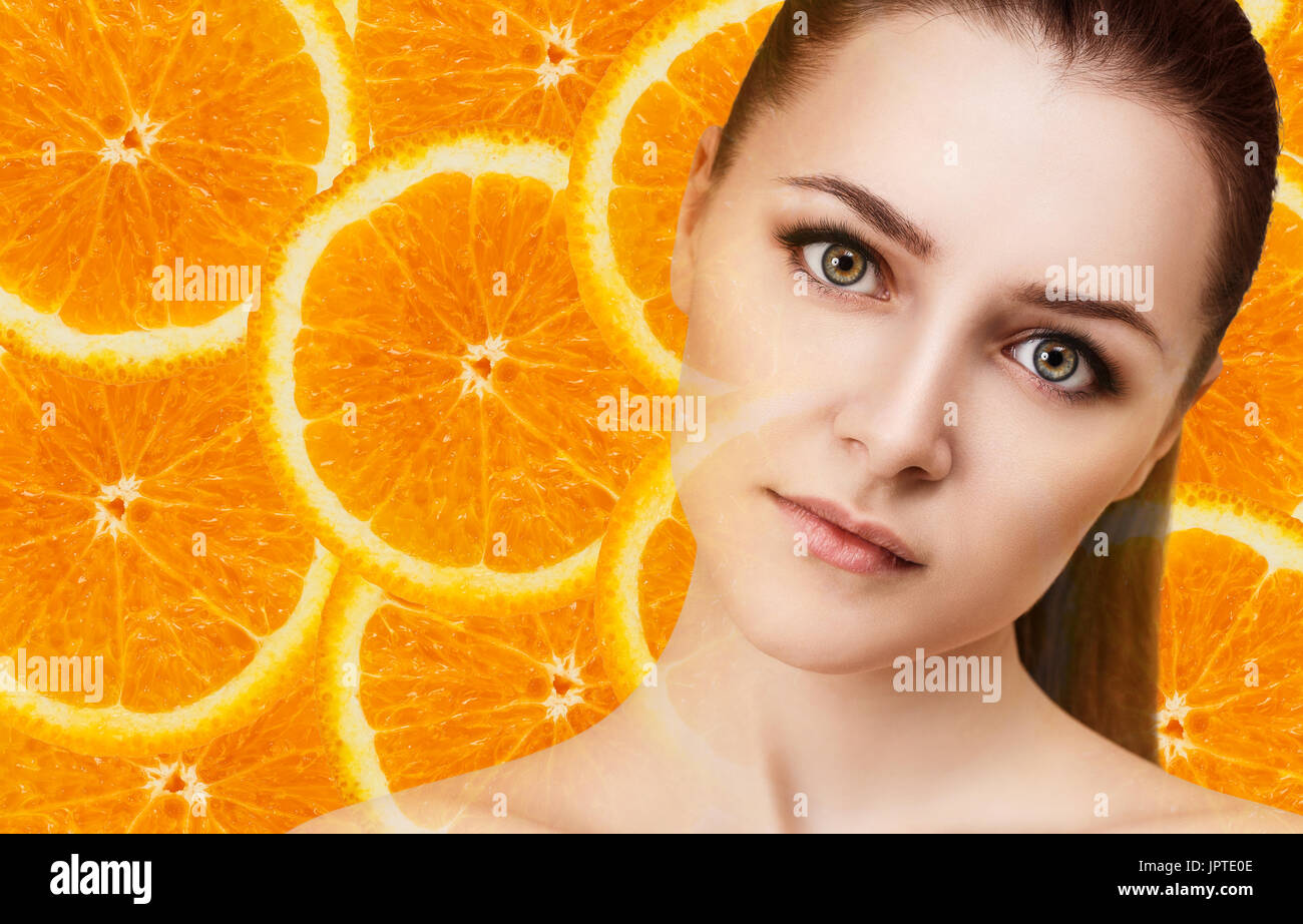 Giovane donna su orange fette di frutta dello sfondo. Foto Stock