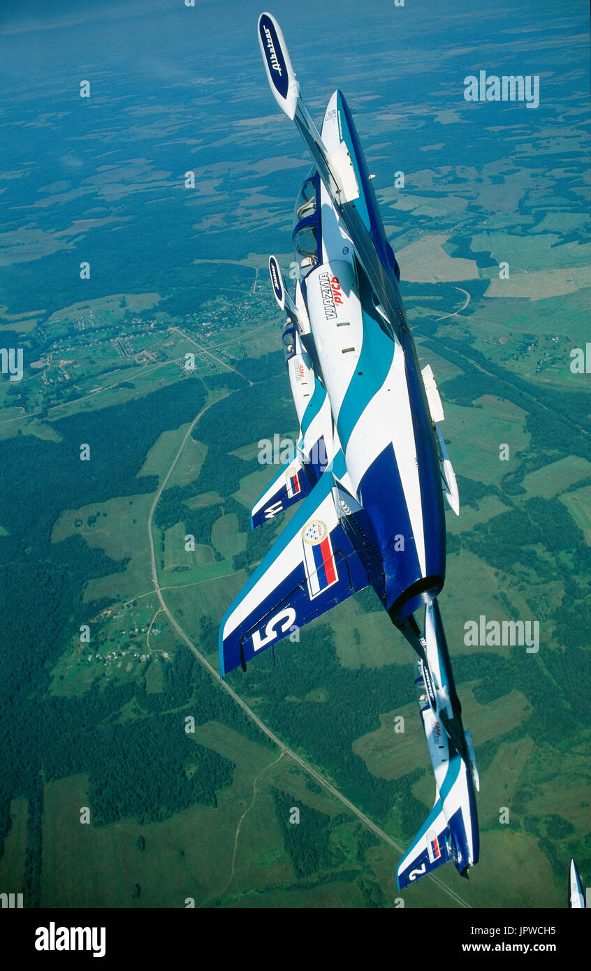 Aeronautica militare russo Team Rus Aero Vodochody L-39 Albatross formazione in un coltello climbing capovolgere verdi campi e foreste Foto Stock