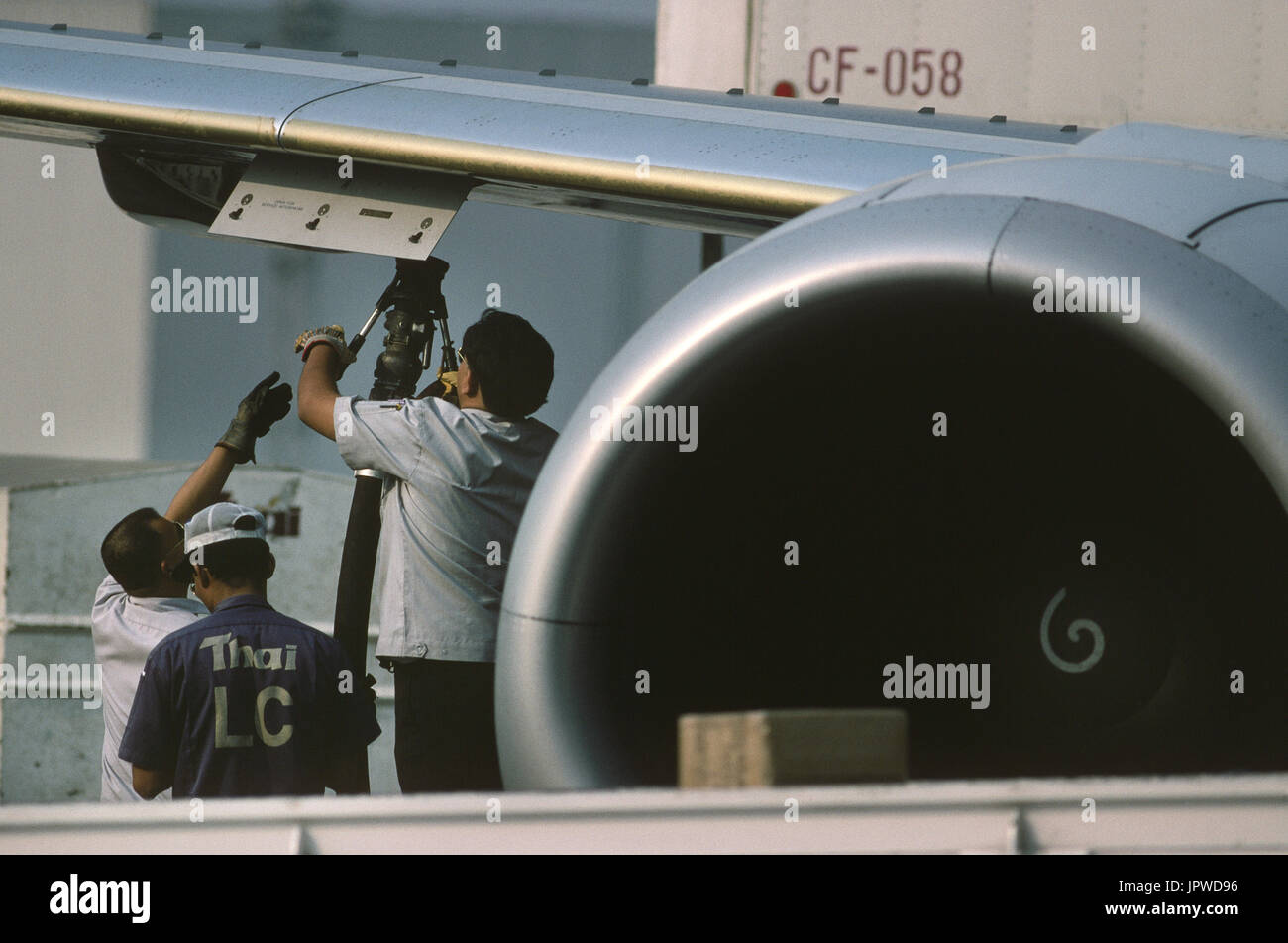 Autofornitori allegando un combustibile-tubo verso la parte inferiore del parafango di un Boeing 737-300 parcheggiata Foto Stock