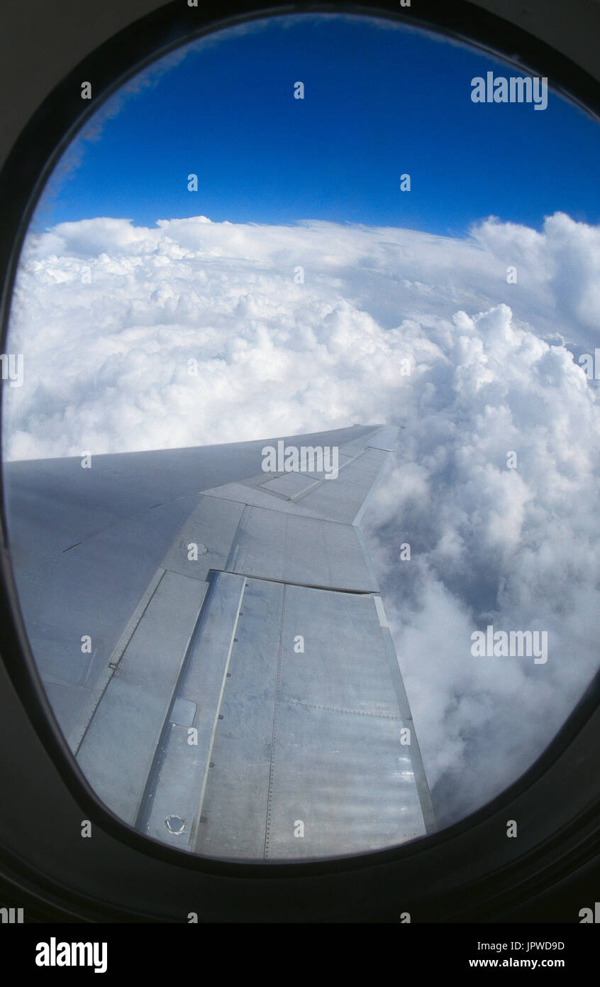 Ala e del bordo di uscita della flaps retratti su un Northwest Airlines McDonnell Douglas DC-10 con un solido strato di cumulus nuvole sotto Foto Stock