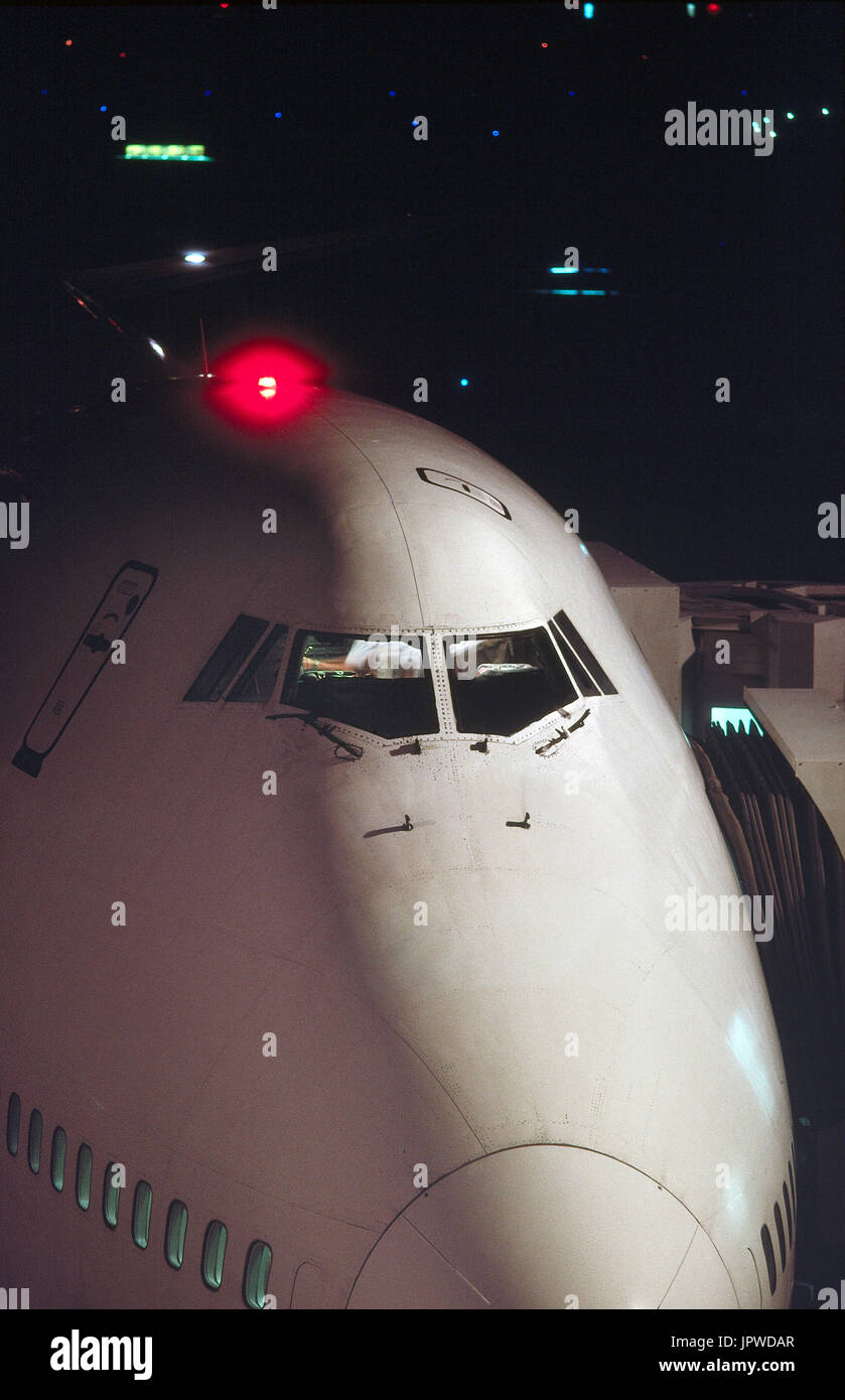 Naso e il parabrezza di un Boeing 747-200 durante la notte con una luce rossa sulla parte superiore del pianale superiore lampeggia durante la sosta al cancello Foto Stock