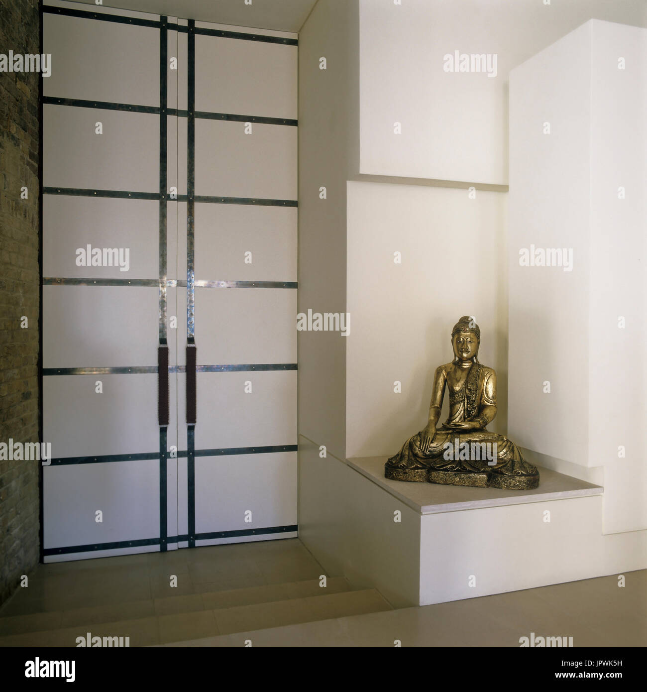 Scultura di buddha e porte doppie Foto Stock