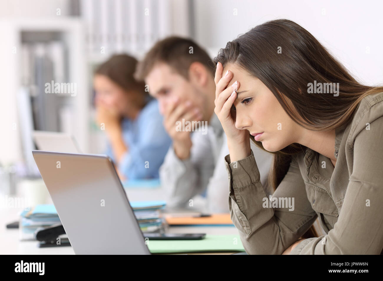 Ritratto di tre dipendenti preoccupati la lettura di cattive notizie sulla linea in ufficio Foto Stock