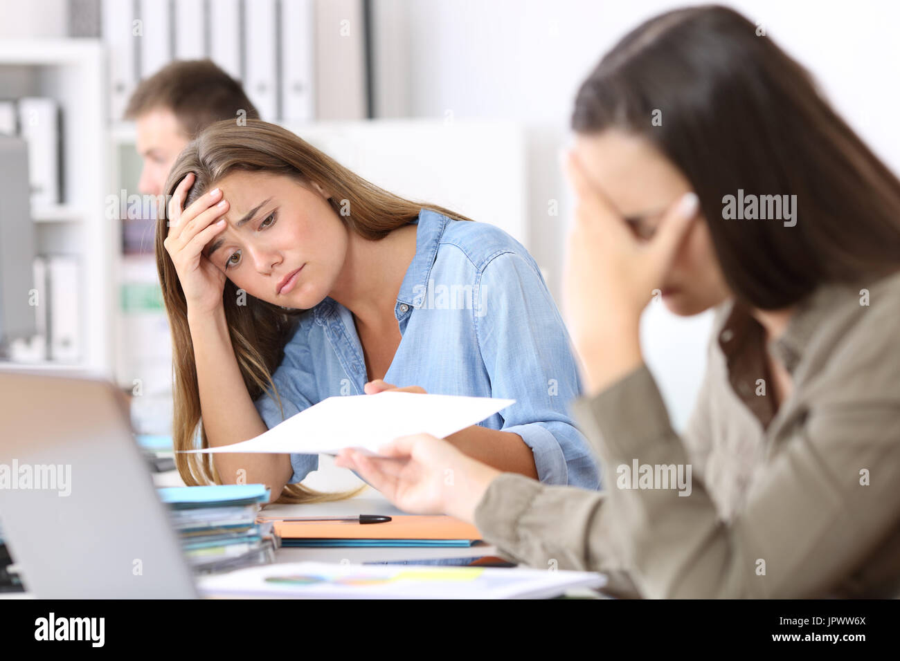 Ritratto di due dipendenti preoccupati ricezione cattiva notizia in un documento di Office Foto Stock