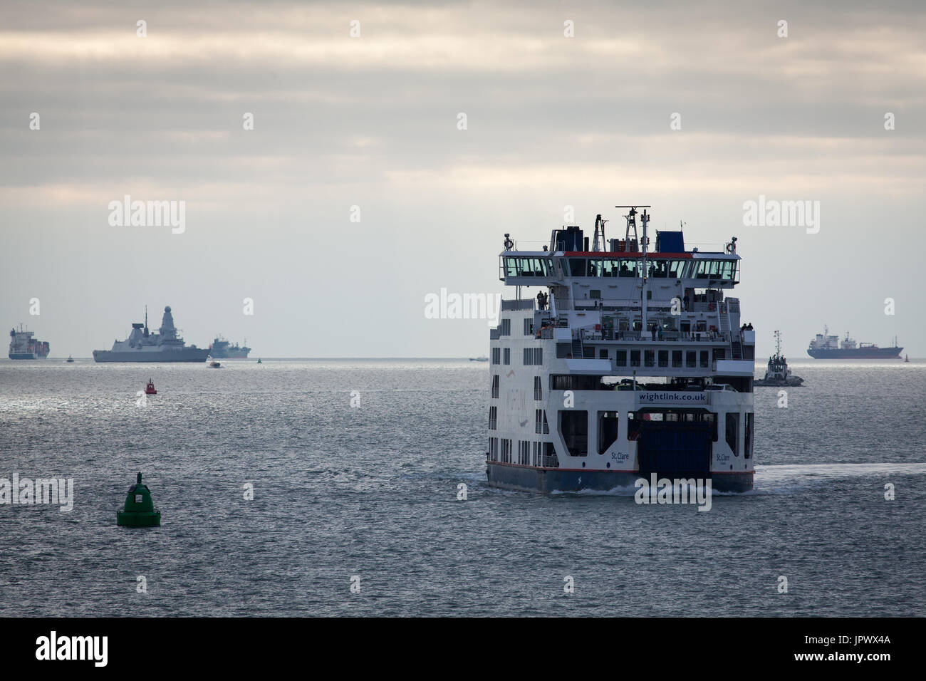 Il Wightlink traghetto per auto, Santa Chiara, avvicinando il porto di Portsmouth come HMS Diamond, la Royal Navy Destroyer, vele dietro a distanza Foto Stock