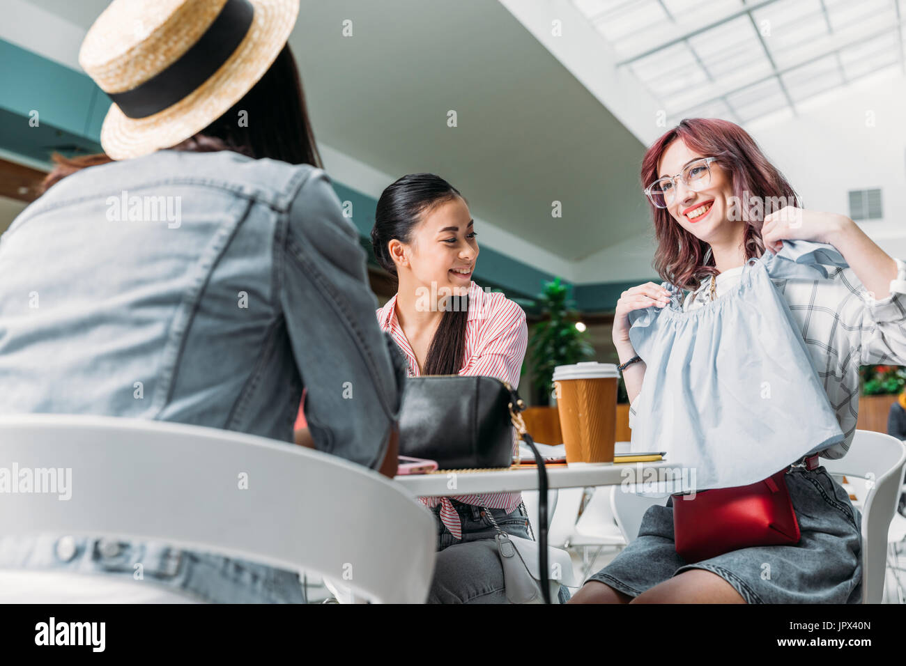 Elegante giovani donne seduti insieme nel centro commerciale per lo shopping con il nuovo abbigliamento di moda, giovani ragazze il concetto di shopping Foto Stock