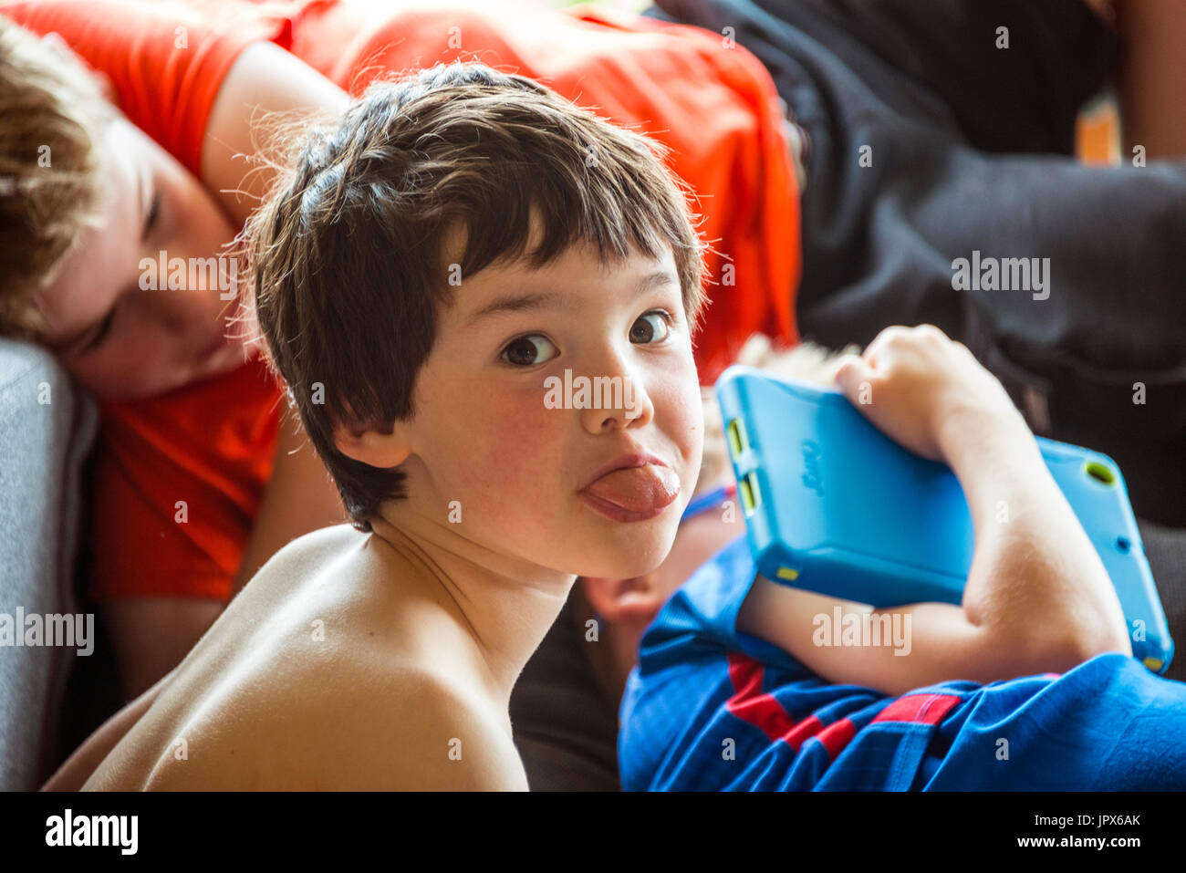 Ragazzo di 5 anni, mettendo la lingua di fuori alla fotocamera Foto Stock