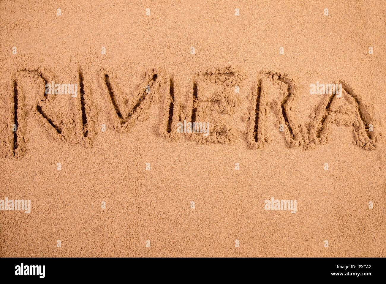 Riviera scritto in morbida sabbia bagnata su una spiaggia Foto Stock