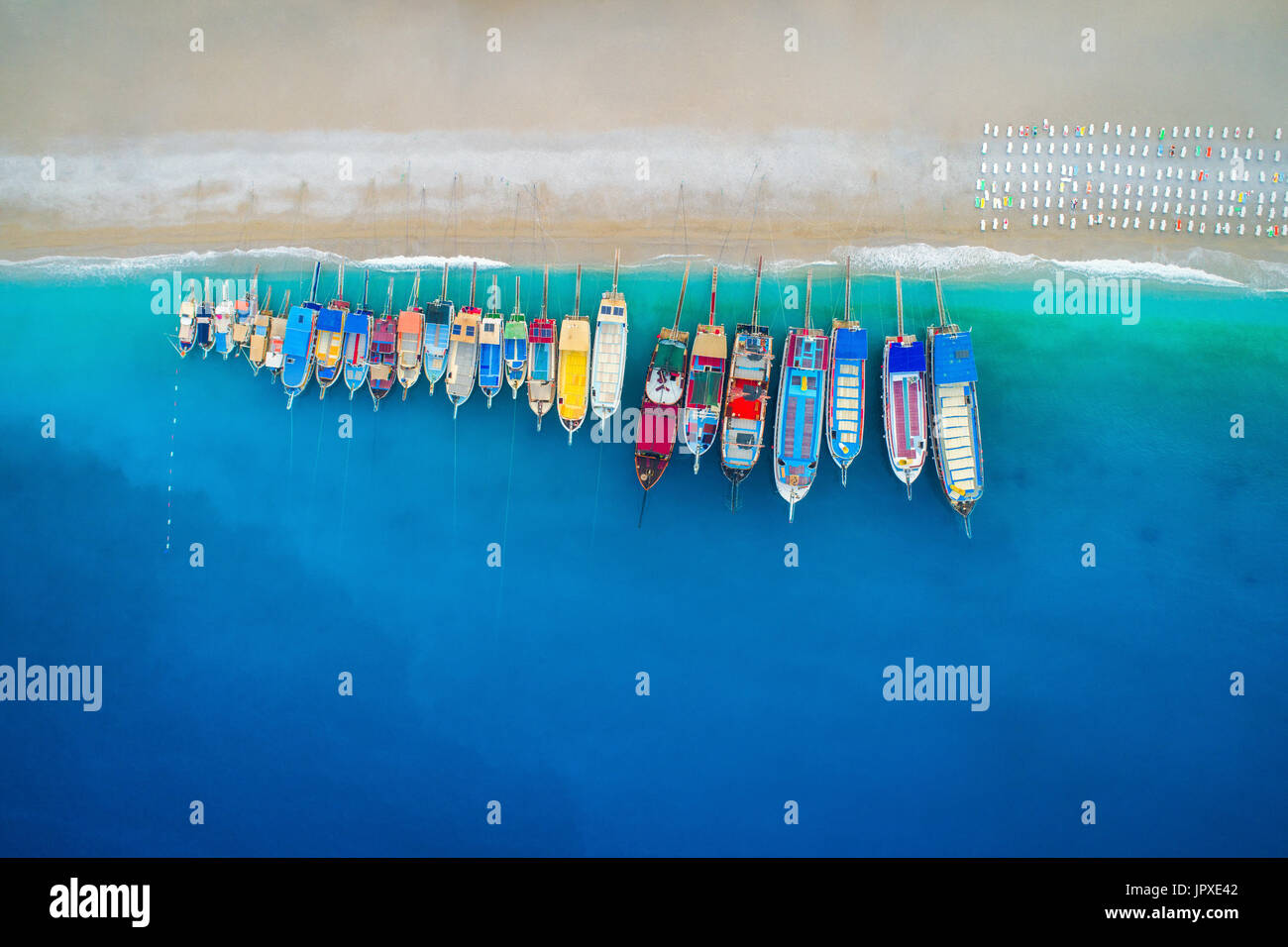 Vista aerea di barche colorate nel mare mediterraneo in Oludeniz, Turchia. Bella estate seascape con navi, chiare acque azzurre e la spiaggia sabbiosa di Sun Foto Stock