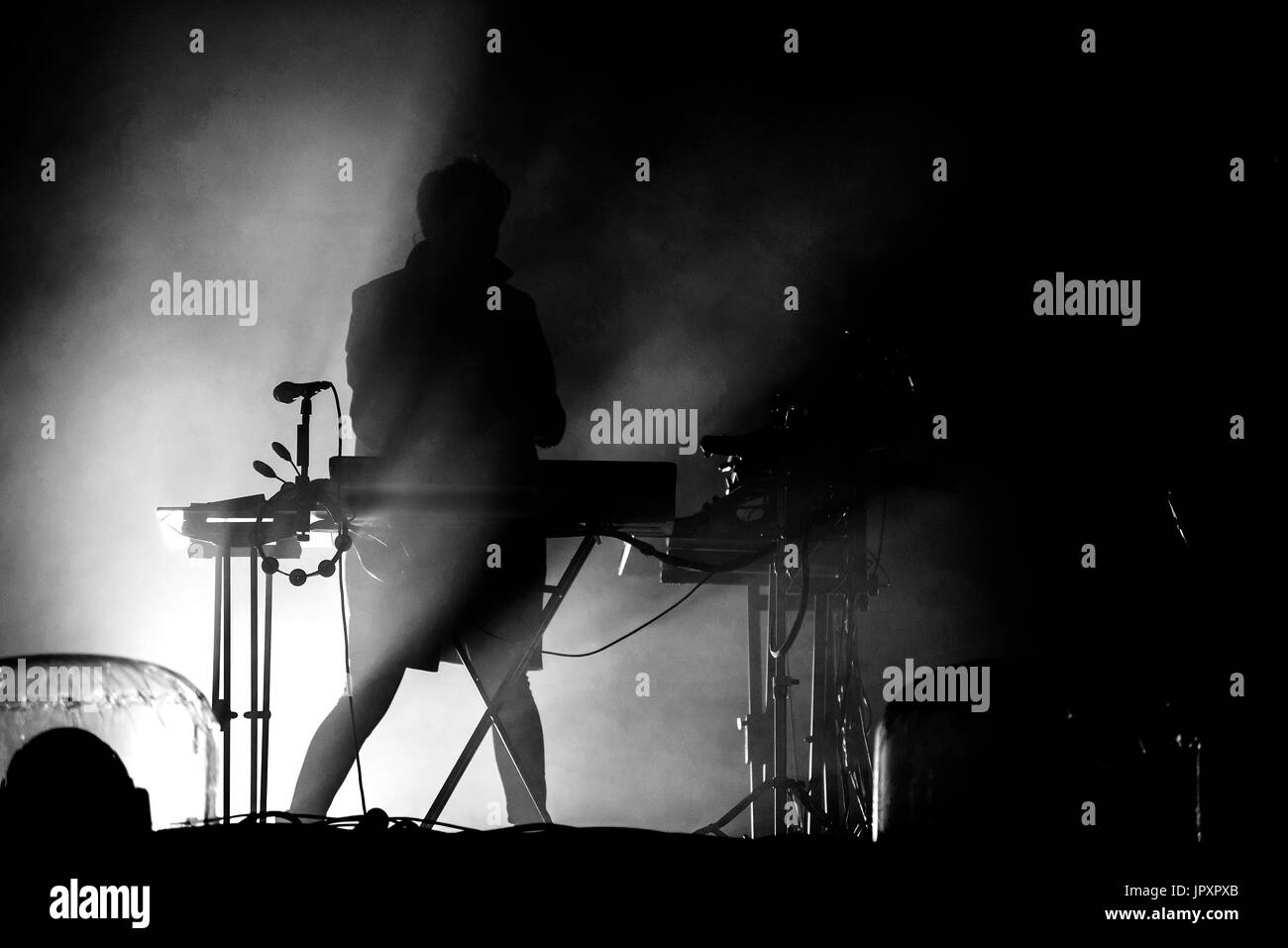 Silhouette di un tastierista suonare dal vivo nelle luci da palco Foto Stock
