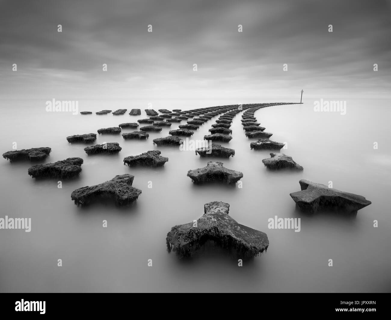 Una lunga esposizione immagine del mare difese a Felixstowe. Foto Stock