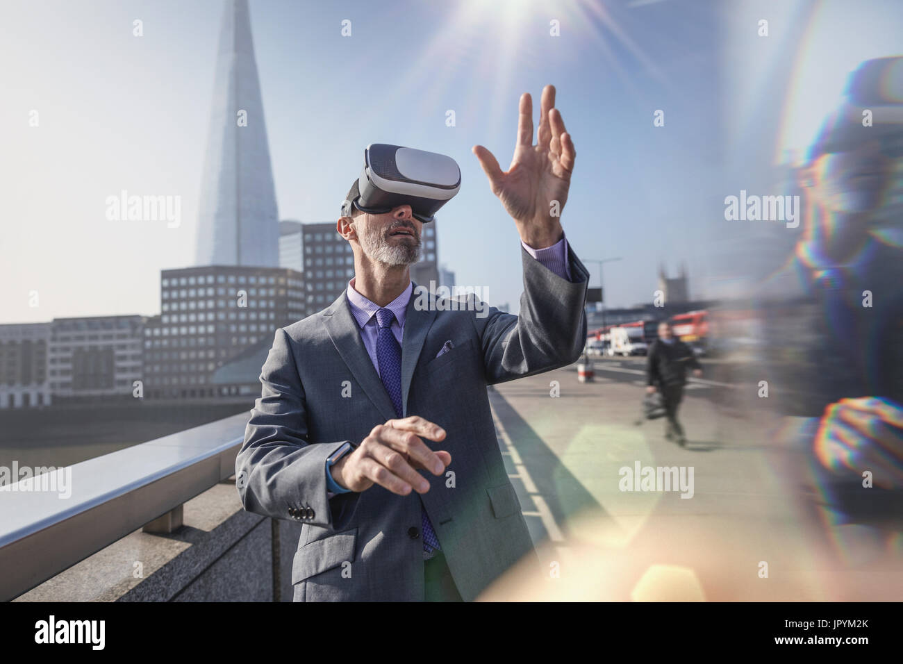 Imprenditore utilizzando la realtà virtuale del simulatore su occhiali da sole ponte urbano, London, Regno Unito Foto Stock