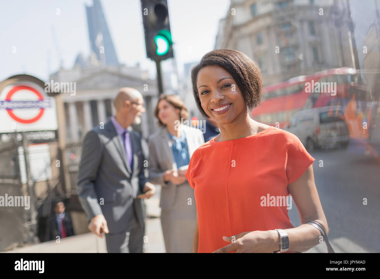 Ritratto sorridente imprenditrice sulla soleggiata città urban Street, Londra, Regno Unito Foto Stock