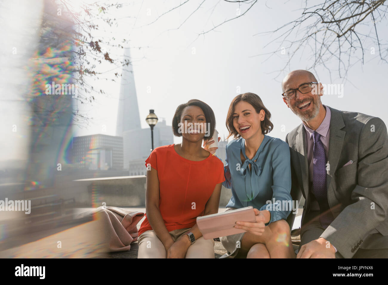 Ritratto sorride la gente di affari con tavoletta digitale nel soleggiato parco urbano Foto Stock