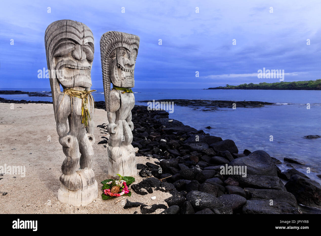 HI00233-00...Hawai'i - Hale o Keawe (Ki'i) Immagini in legno guarda permanente sulle rive della Baia di Honaunau in Pu'uhonua o Honaunau National Historic Park. Foto Stock