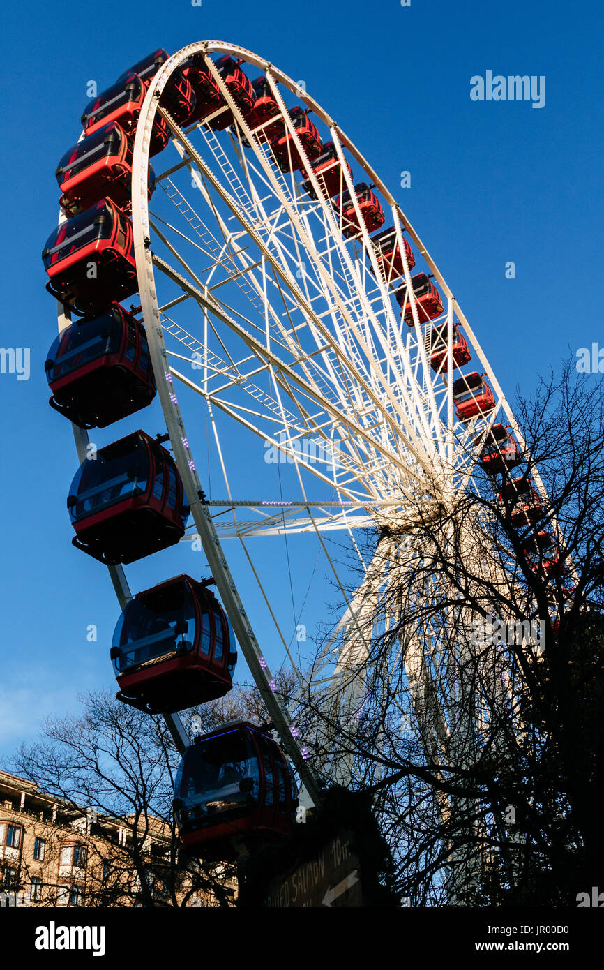 Un colorato di rosso ruota panoramica Ferris in Princess Street Gardens per il Mercatino di Natale di Edimburgo, Scozia Foto Stock
