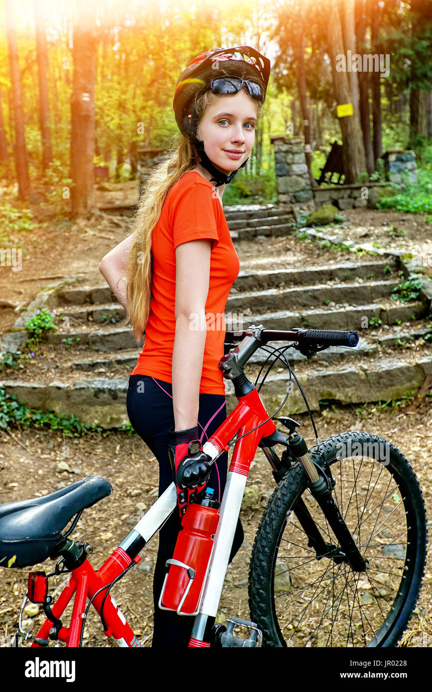 Biciclette ragazza in bicicletta nel parco. Ragazza che indossa il casco e  grande zaino Foto stock - Alamy